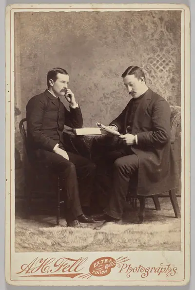 Untitled (seated portrait of two men, one with a book, the other reading a magazine)
