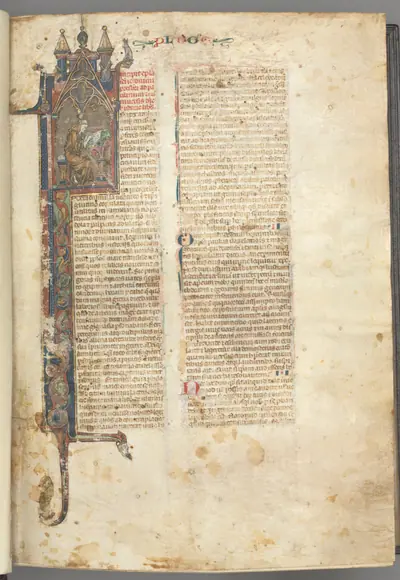 Fol. ir: Prologue, St. Jerome, large historiated initial I, the saint in a brown habit writing at a desk in a gothic architectural frame, with full-length border of foliage and small hybrids, a hare, a dog and a grotesque perched on the foliage extensions
